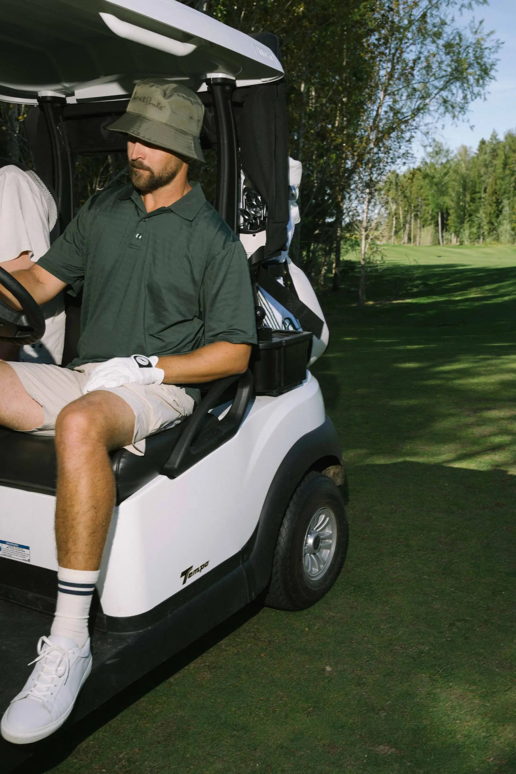 Local_Rule_tech_polo_green_tech_shorts_beige_golfcart_jpg.webp