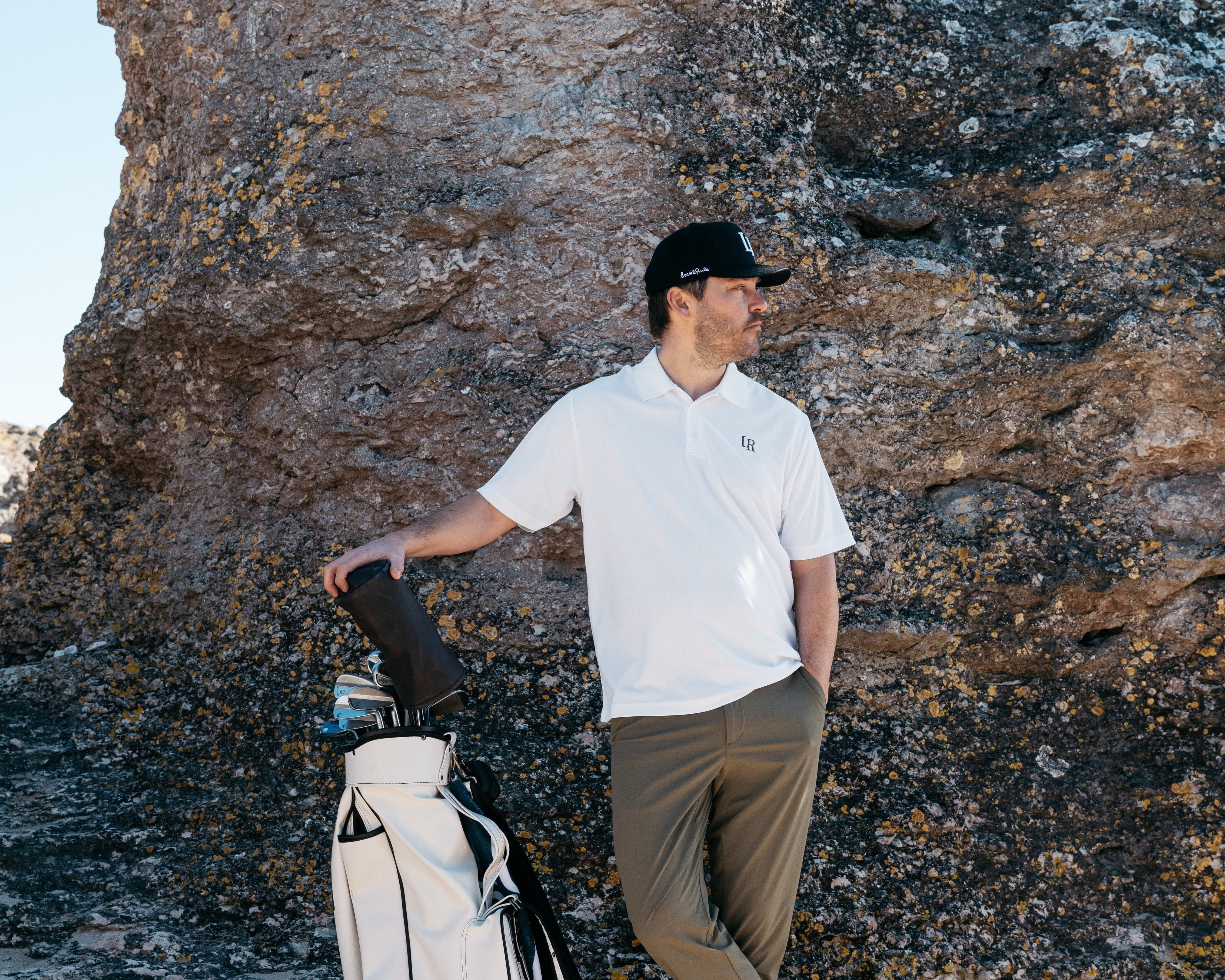 Man i modern golf outfit med tekniska plagg på golfbana, lager anpassade efter väder, golf outfit tips herr