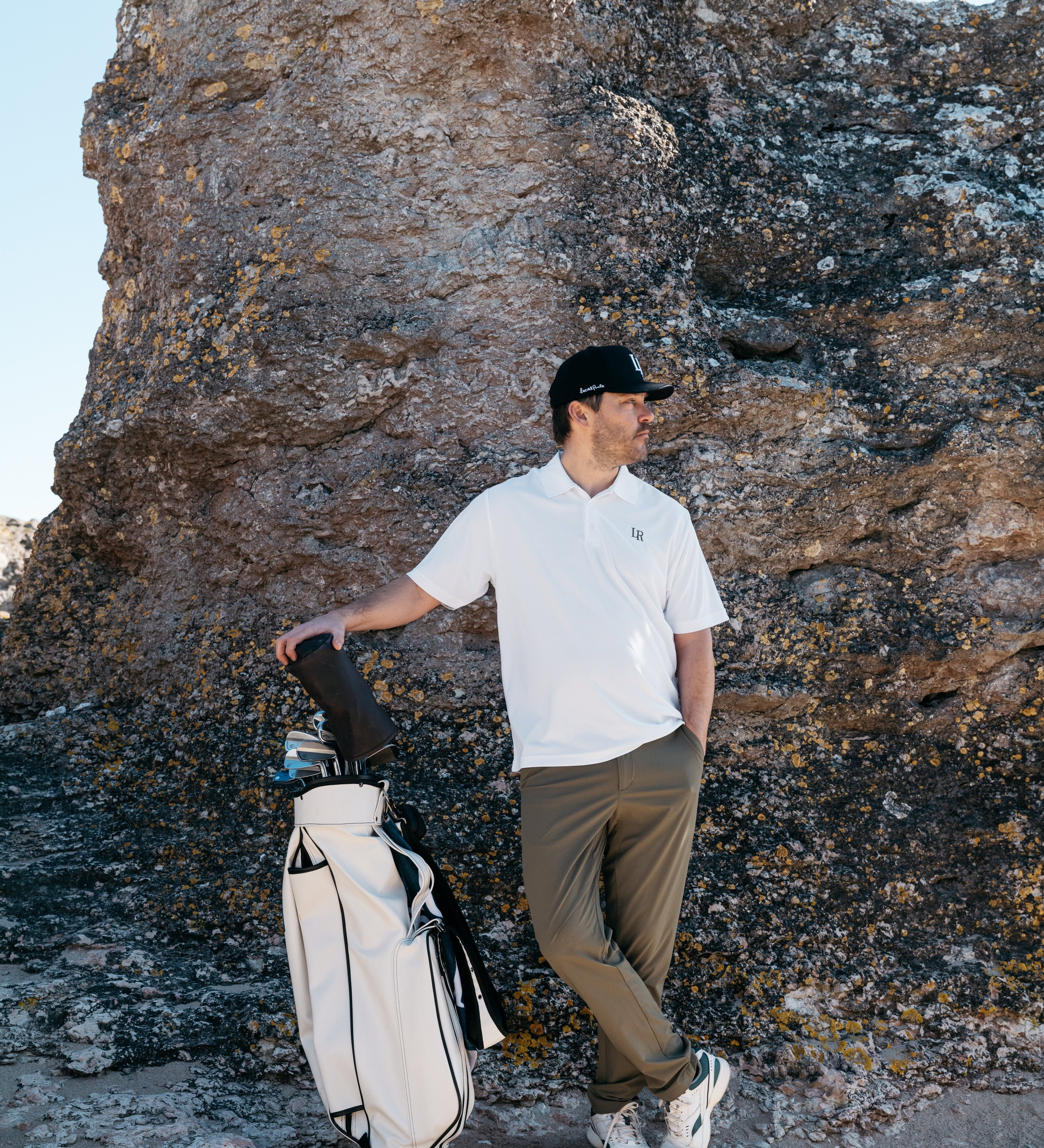 Man i modern golf outfit med tekniska plagg på golfbana, lager anpassade efter väder, golf outfit tips herr