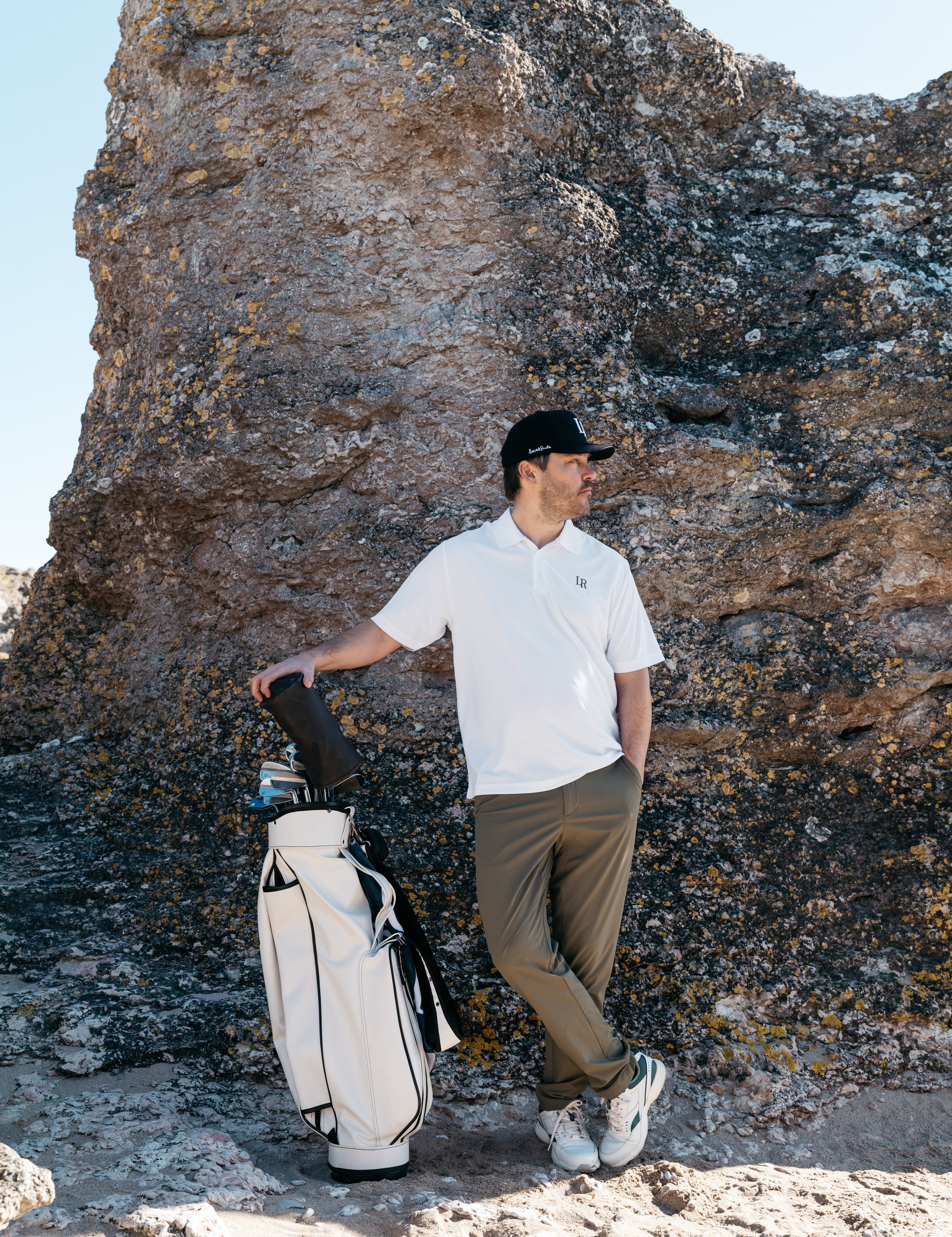 Man i modern golf outfit med tekniska plagg på golfbana, lager anpassade efter väder, golf outfit tips herr