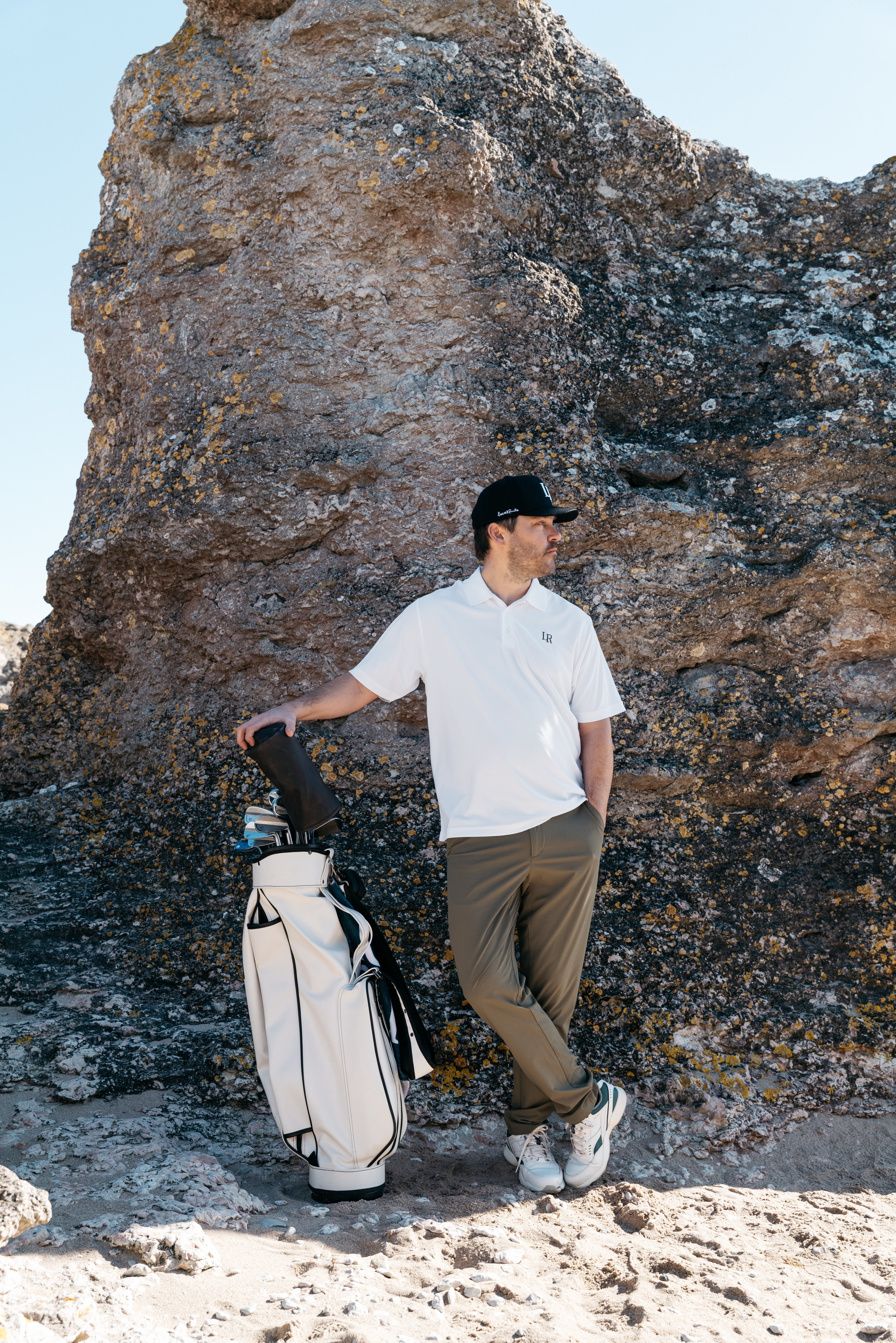 Adults learning golf for beginners at a driving range, wearing stylish premium golf apparel, practicing comfortable swings