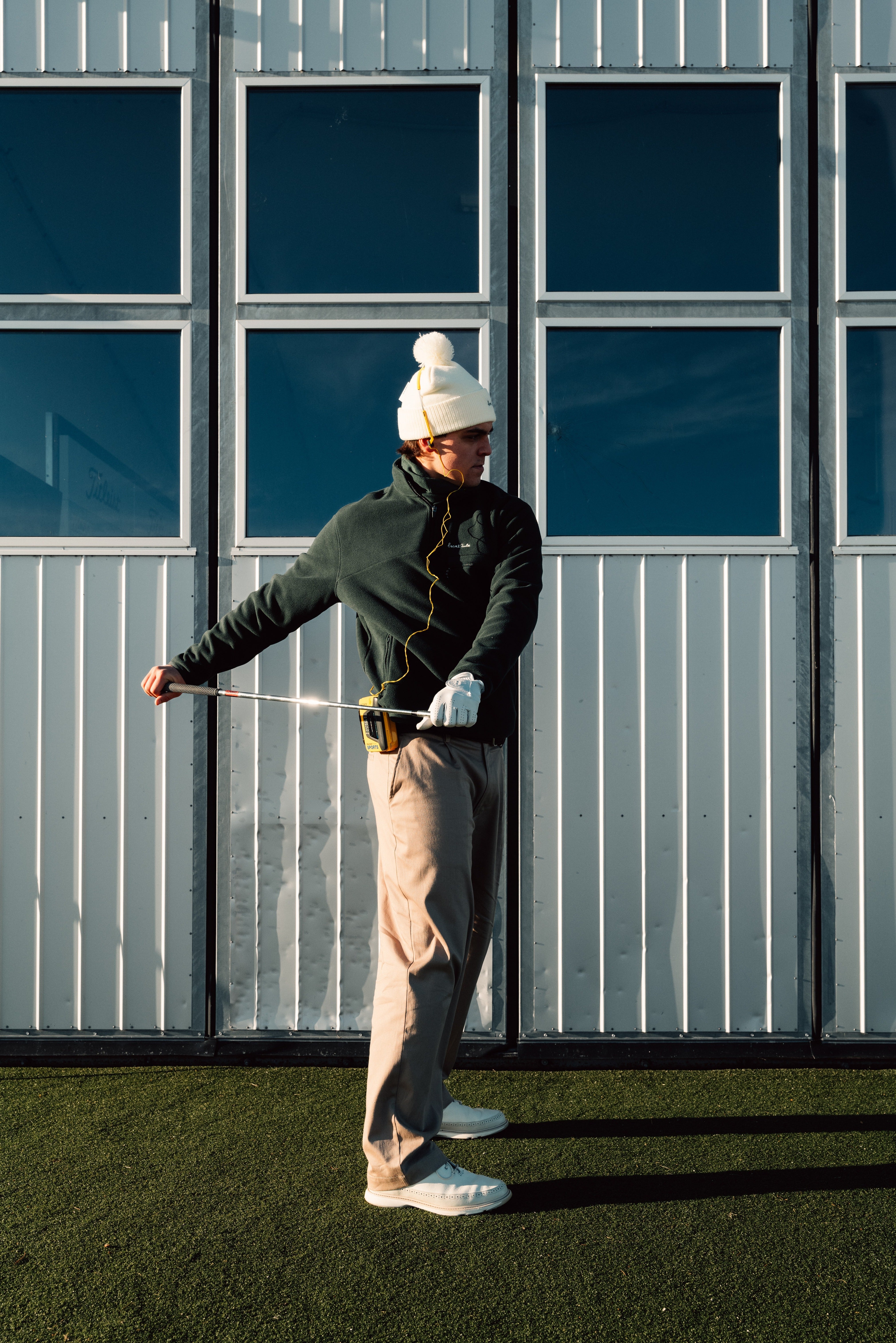 Golfer performing strength and mobility exercises to hit longer in golf, wearing premium Scandinavian golf apparel on the course