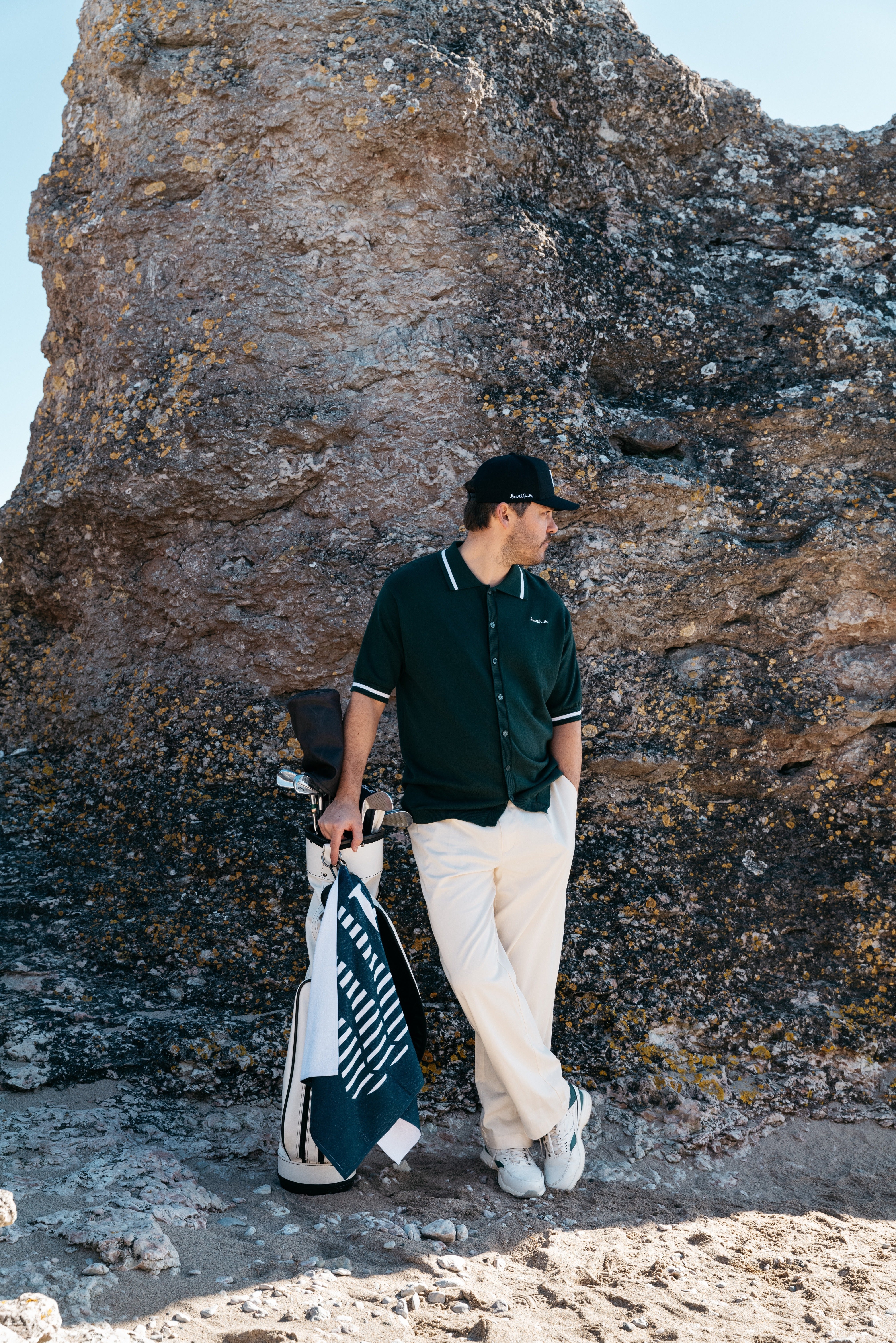 Golfare klädda enligt golf dresscode står på fairway nära klubbhus i stilrena och funktionella kläder