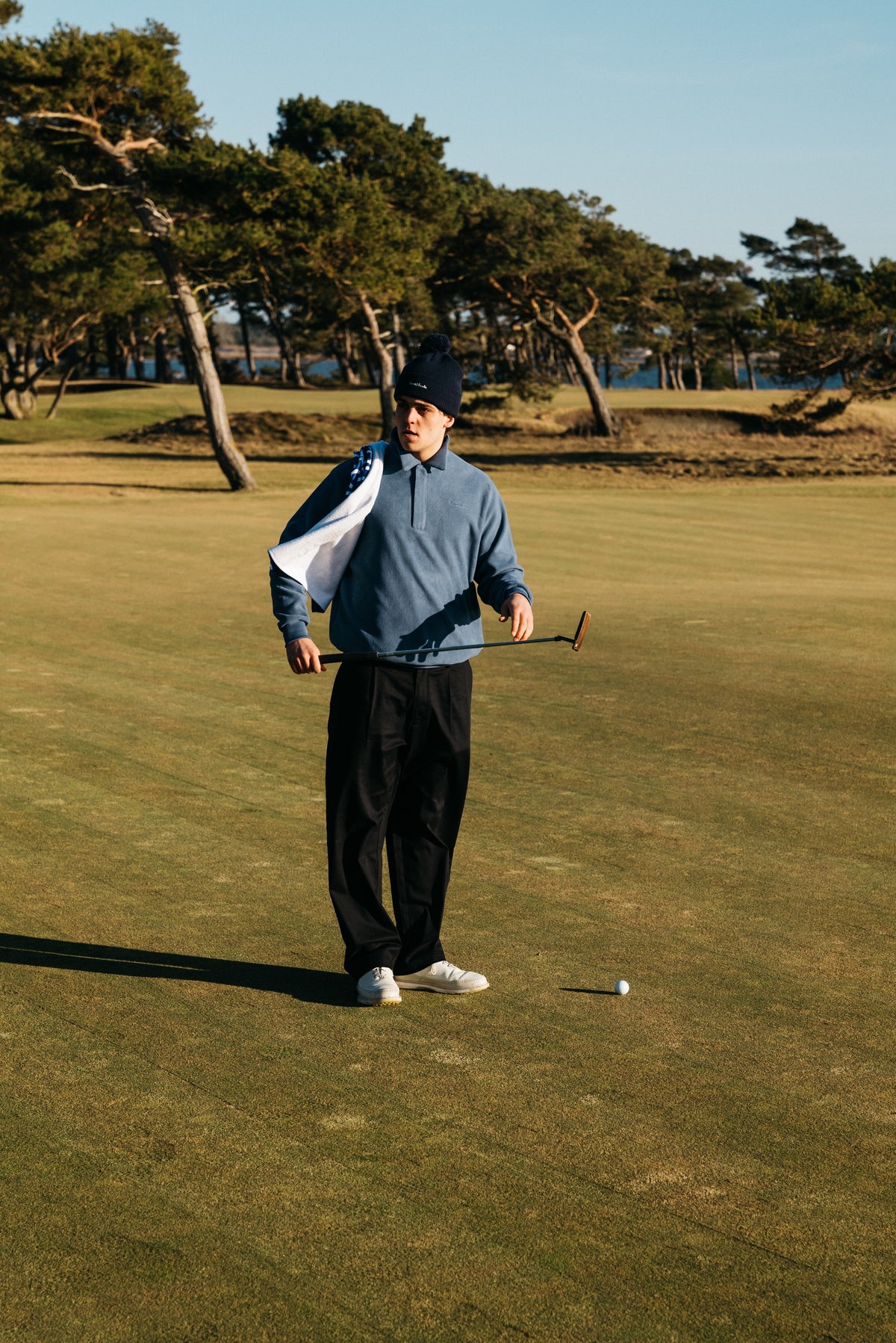 Golfer practicing approach shots on a manicured course, demonstrating how to lower your golf handicap with focused training