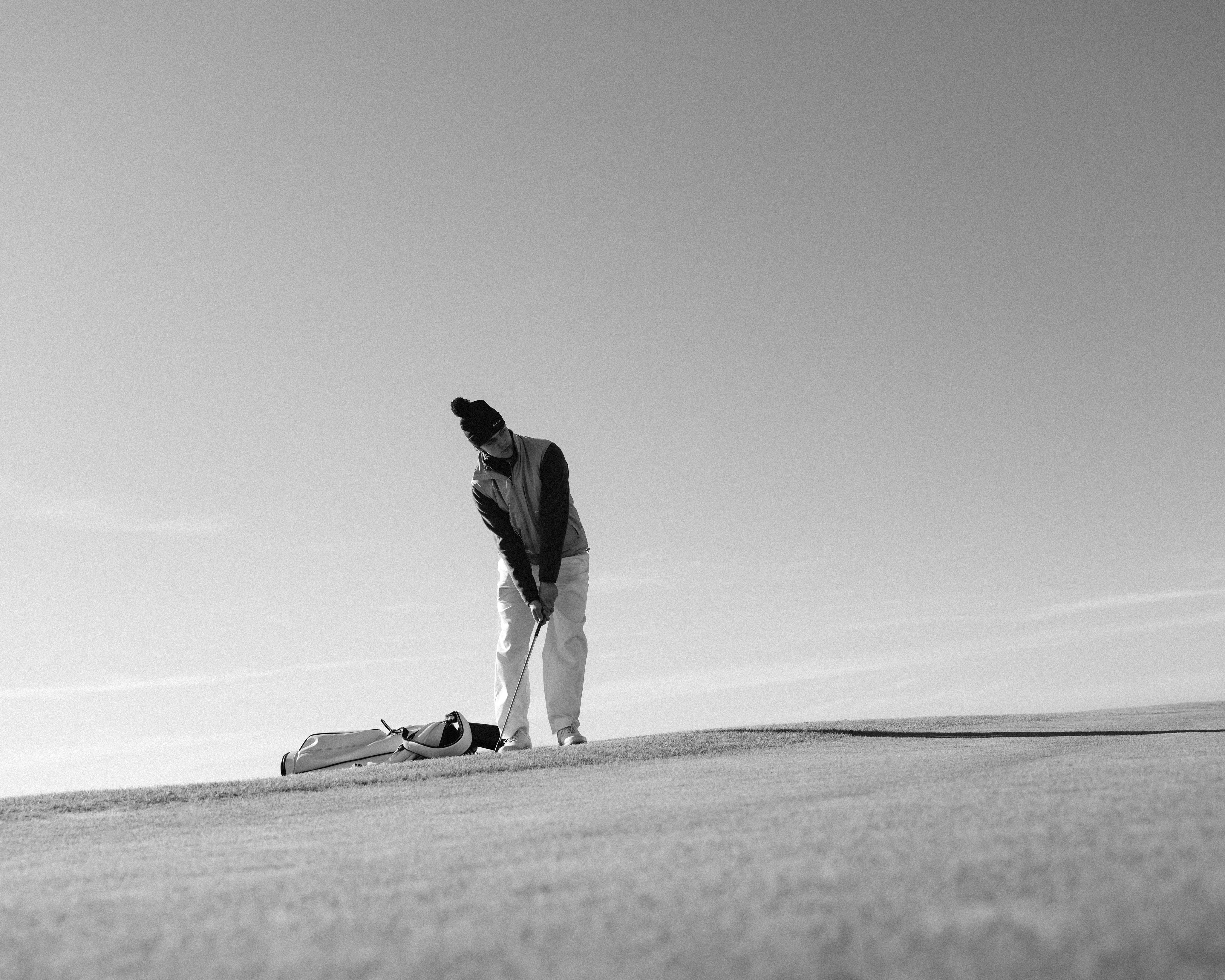 Golfspelare i par diskuterar bästboll golf regler på greenen med scorekort och klubbor under en fyrbollsmatch