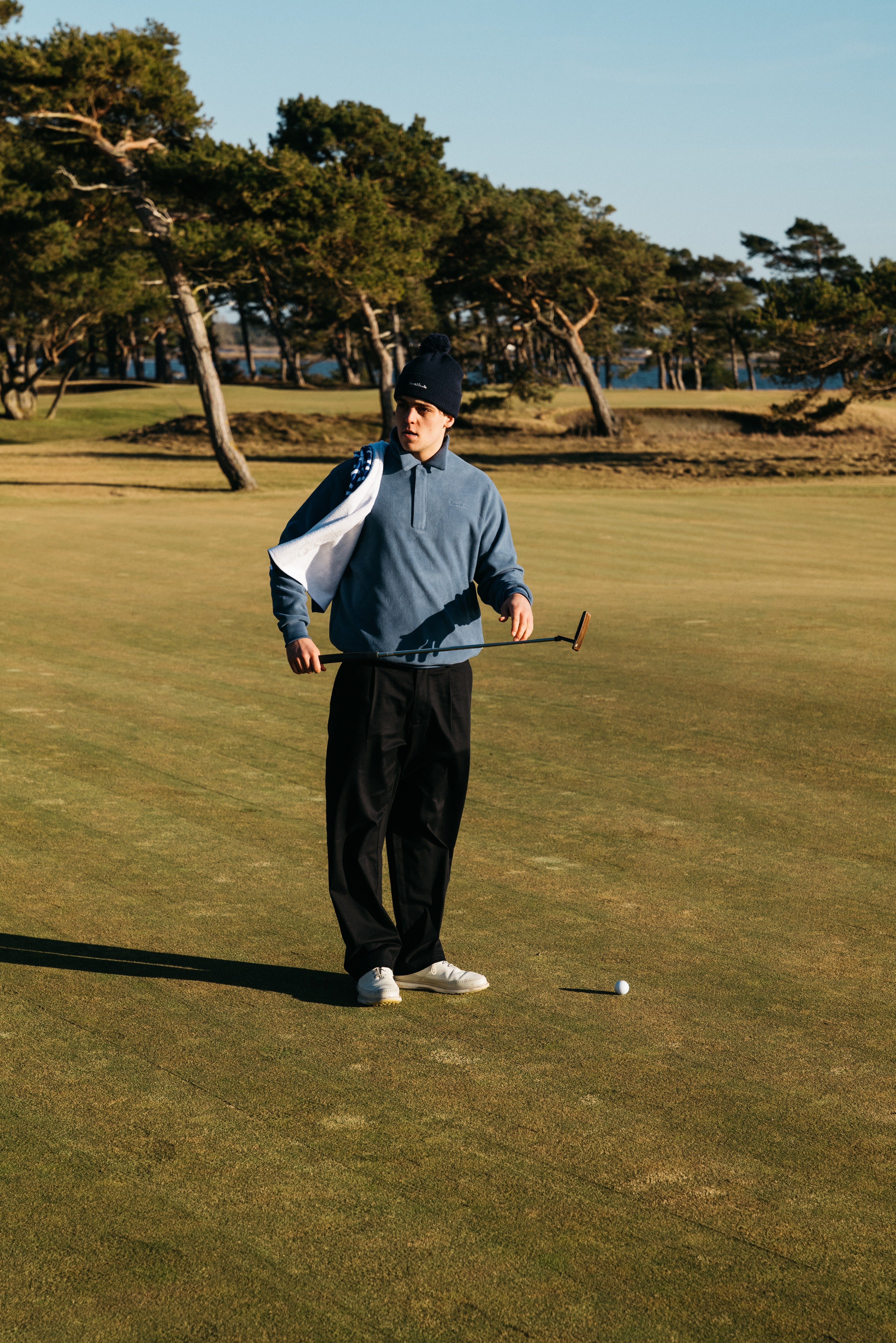 Golfspelare anger sitt handicap golf på digitalt scorekort vid en green med klubbhus i bakgrunden