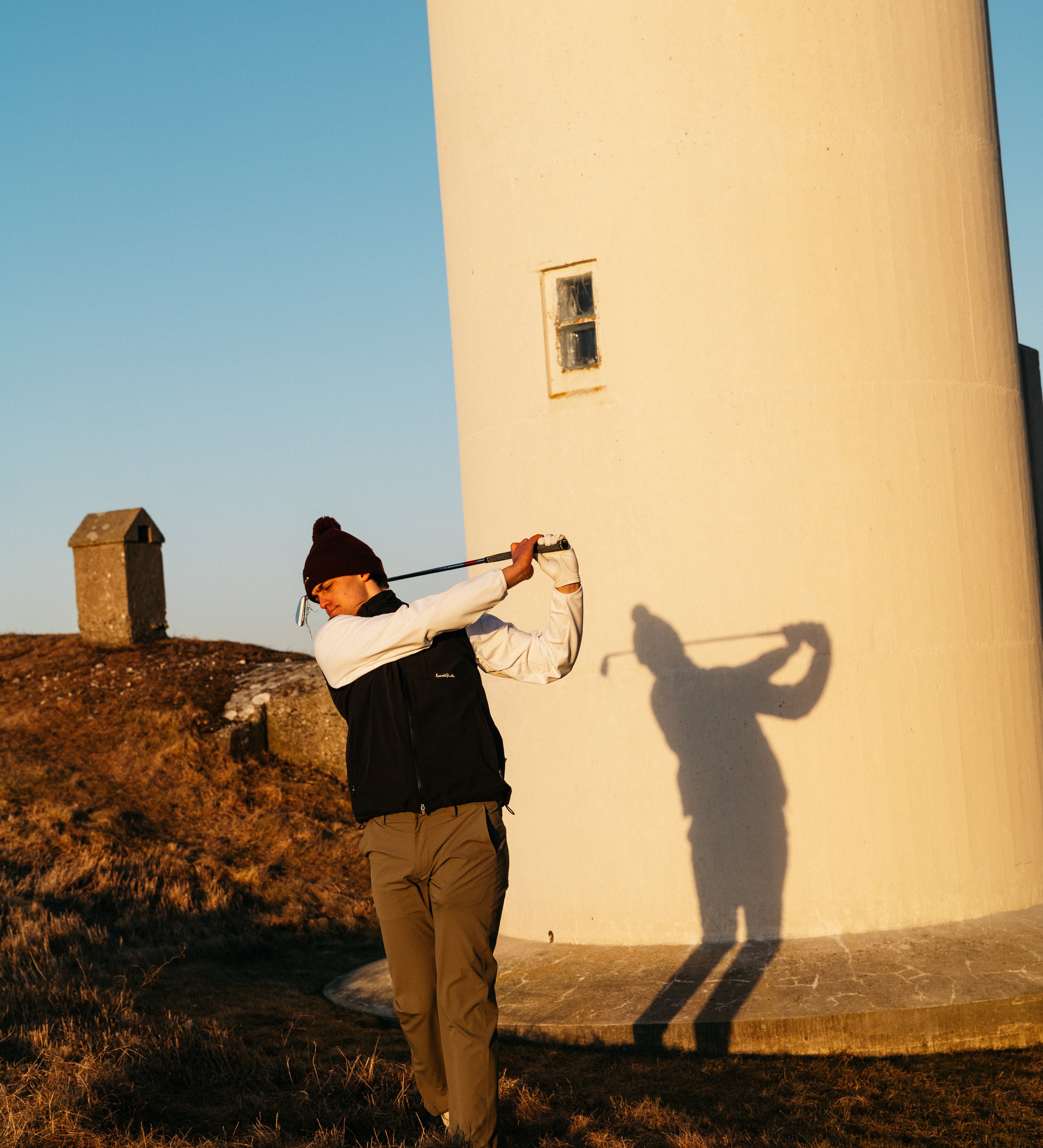 Golfspelare på grön bana under stora golftävlingar med publik, prispokal och internationella flaggor